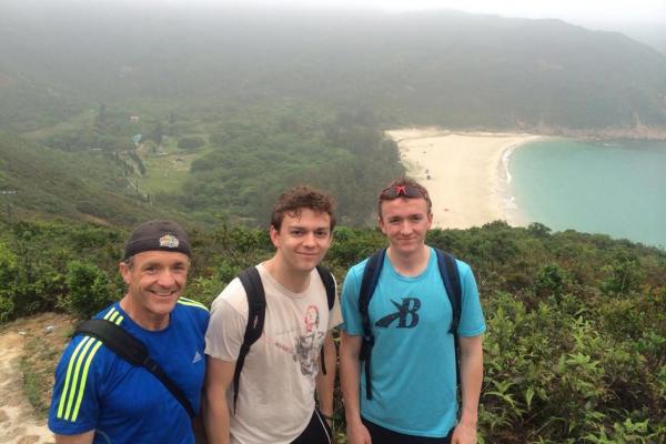 Liam (middle) with, his dad and brother, on a hike with one of Hong Kong's many beaches in the background.&nbsp;
